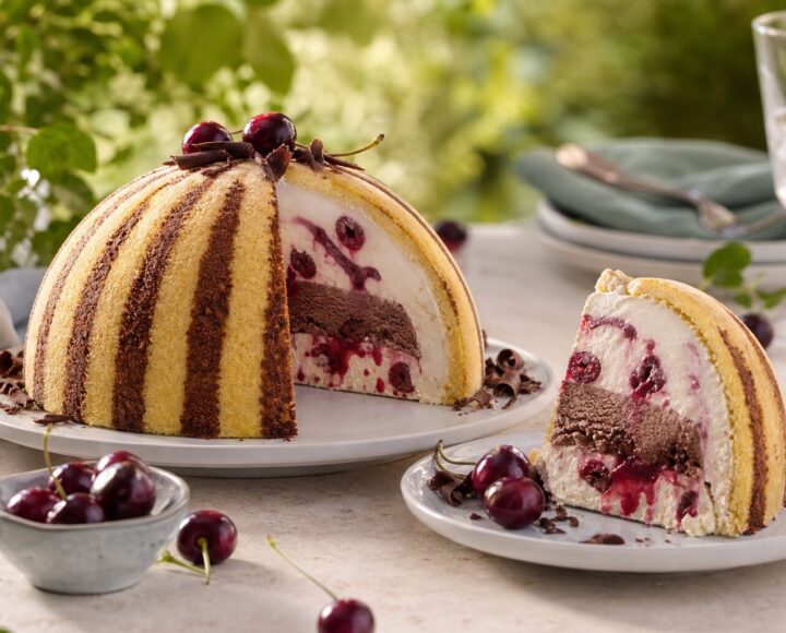 Dome-shaped ice-cream zuccotto with Amarena and chocolate layers and one slice served.