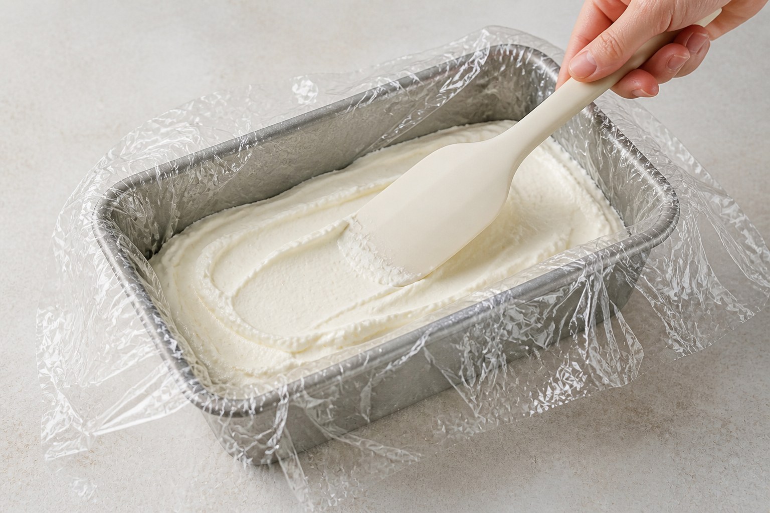 Primo strato di crema in uno stampo da plumcake rivestito